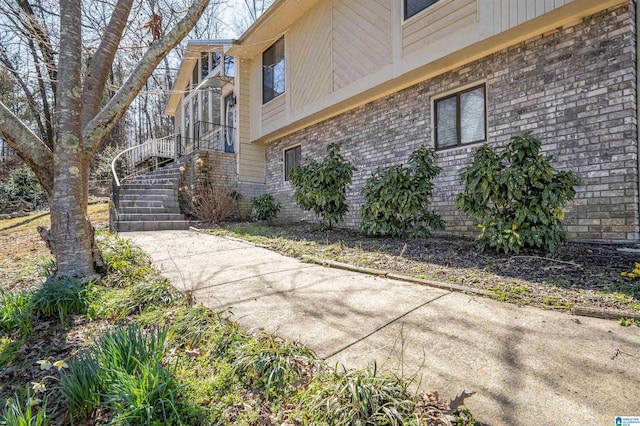 view of home's exterior with stairway and brick siding