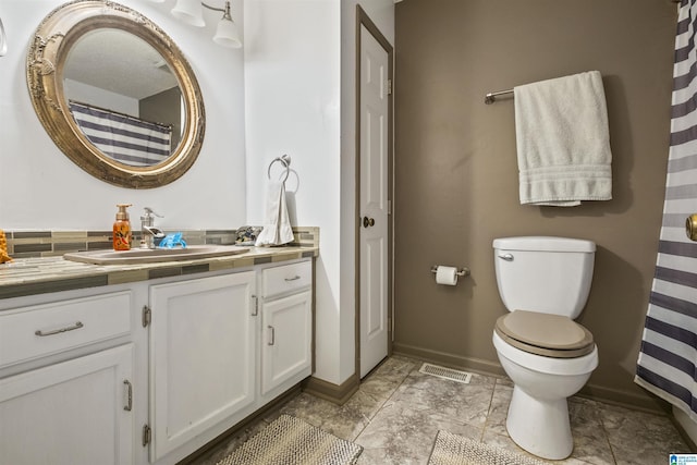 full bath with toilet, vanity, visible vents, and baseboards