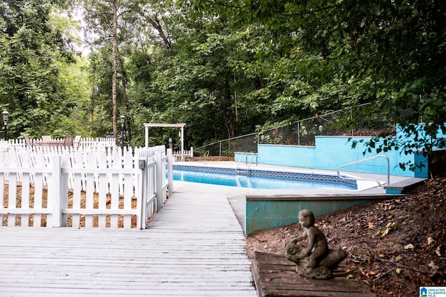 pool featuring fence and a deck