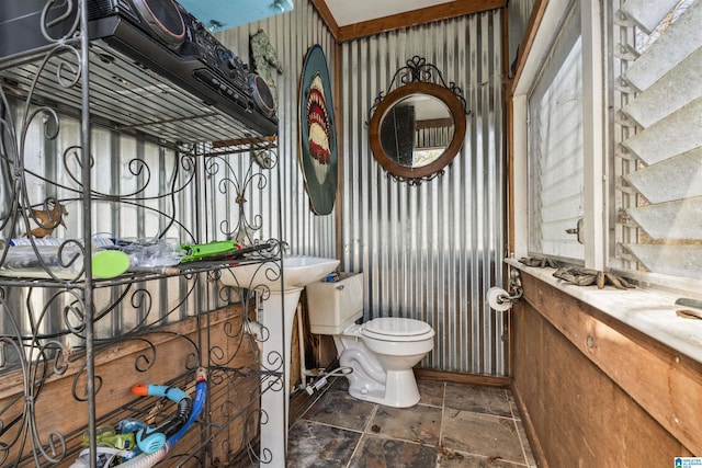 bathroom with toilet and stone tile flooring