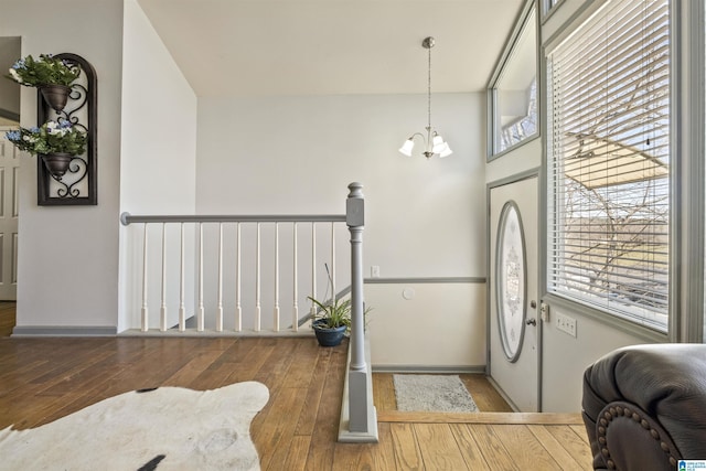 entryway featuring wood-type flooring, baseboards, and an inviting chandelier