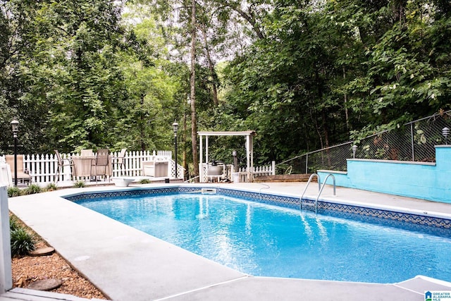 view of swimming pool featuring a patio area, fence, and a fenced in pool