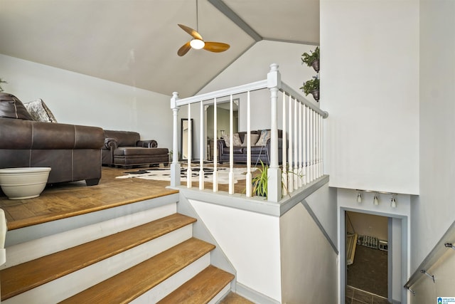 staircase with lofted ceiling and a ceiling fan