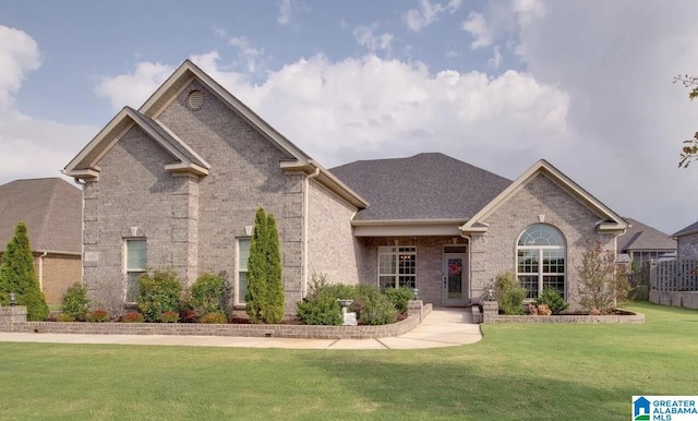 view of front of home featuring a front yard, brick siding, and roof with shingles