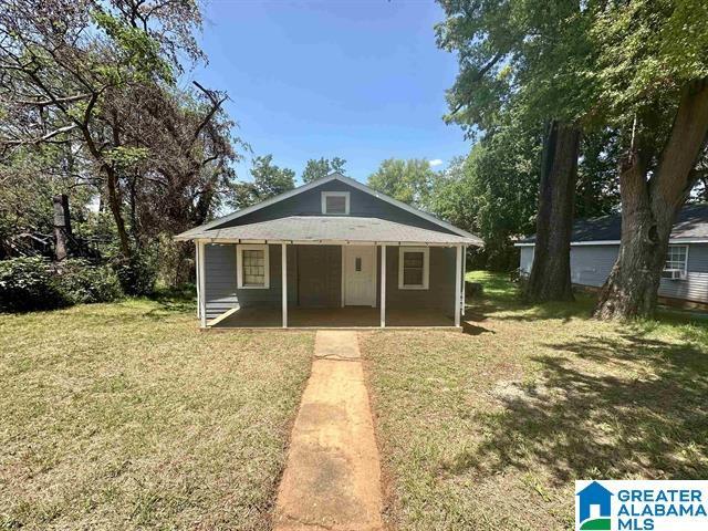 bungalow-style house featuring covered porch and a front yard