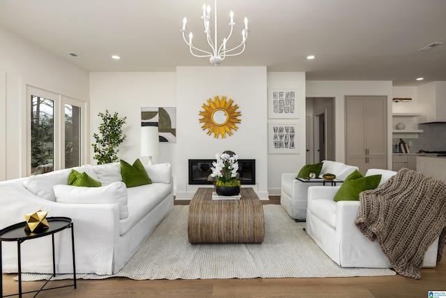 living room with a glass covered fireplace, recessed lighting, light wood-type flooring, and visible vents