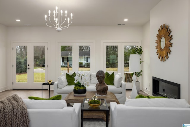 living room with recessed lighting, french doors, wood finished floors, and a glass covered fireplace