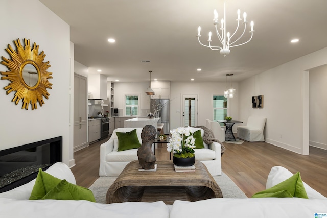 living area with a notable chandelier, recessed lighting, and light wood-type flooring