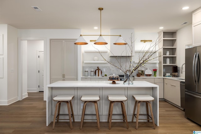 kitchen featuring open shelves, wood finished floors, light countertops, and stainless steel appliances