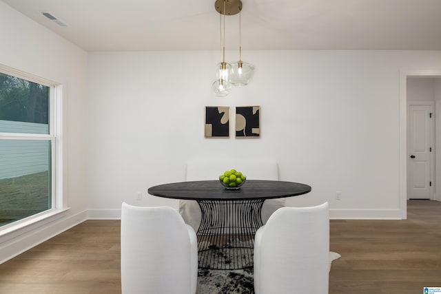 dining space with visible vents, baseboards, and wood finished floors