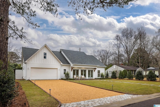 modern farmhouse style home with board and batten siding, driveway, a front yard, and roof with shingles