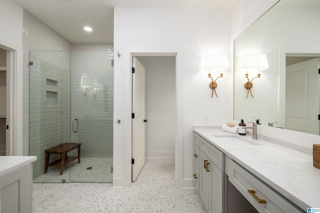 full bathroom with recessed lighting, baseboards, vanity, and a shower stall