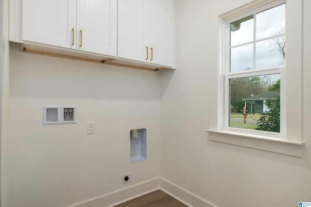 clothes washing area featuring baseboards, hookup for a washing machine, dark wood-style floors, cabinet space, and hookup for an electric dryer