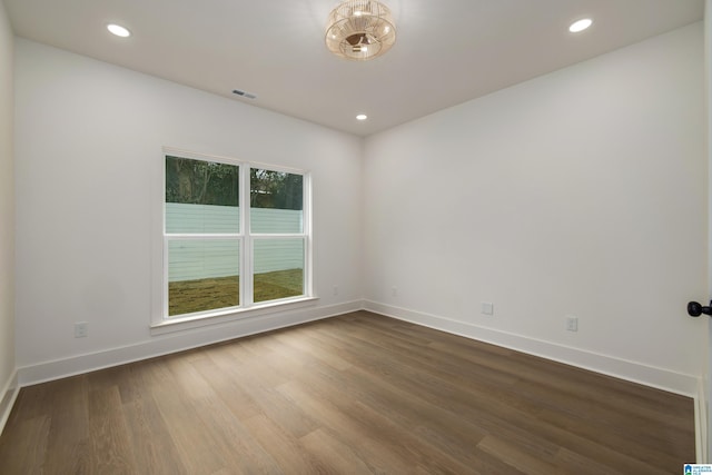 empty room featuring recessed lighting, baseboards, and dark wood-style flooring