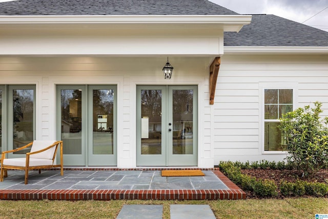 property entrance featuring french doors and roof with shingles