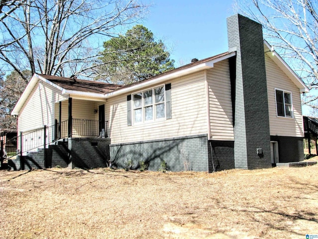 view of property exterior featuring a chimney and brick siding