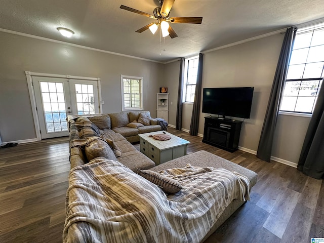 living area featuring dark wood-style flooring, french doors, ornamental molding, ceiling fan, and baseboards