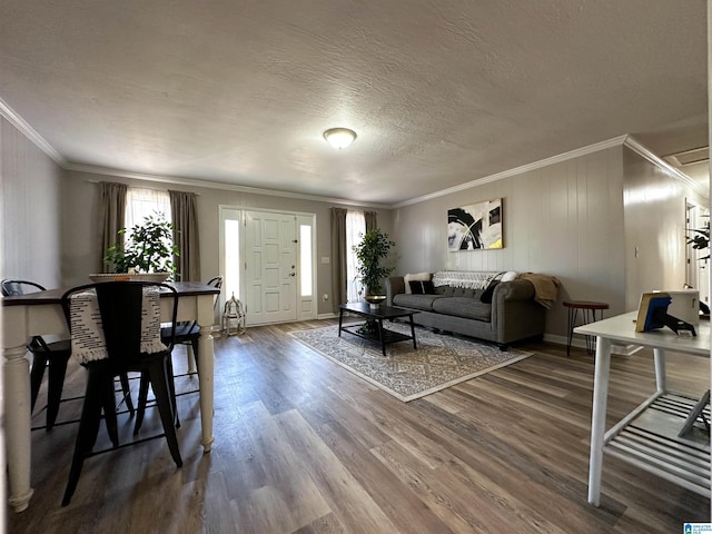 living room featuring crown molding, dark wood finished floors, a textured ceiling, and baseboards