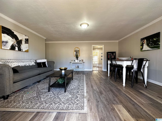 living area with a textured ceiling, baseboards, wood finished floors, and crown molding