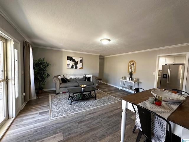 living room featuring dark wood-style floors, baseboards, ornamental molding, and a textured ceiling