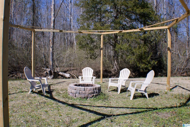 view of yard with a forest view and a fire pit