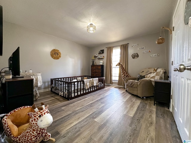 bedroom with baseboards and wood finished floors