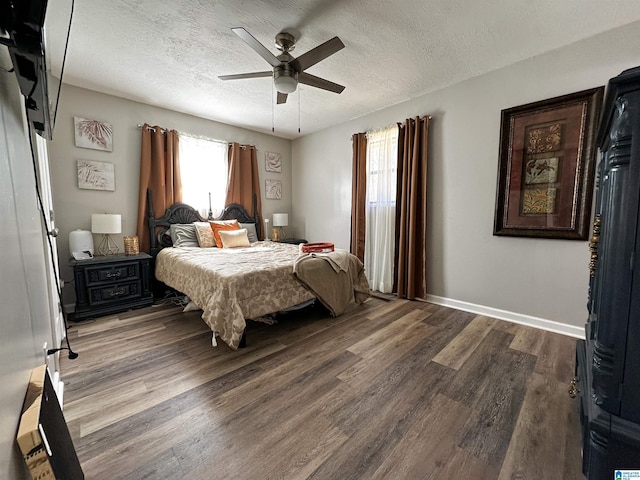 bedroom with a textured ceiling, ceiling fan, wood finished floors, and baseboards