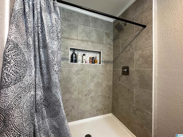 bathroom featuring a textured ceiling, tiled shower, and crown molding