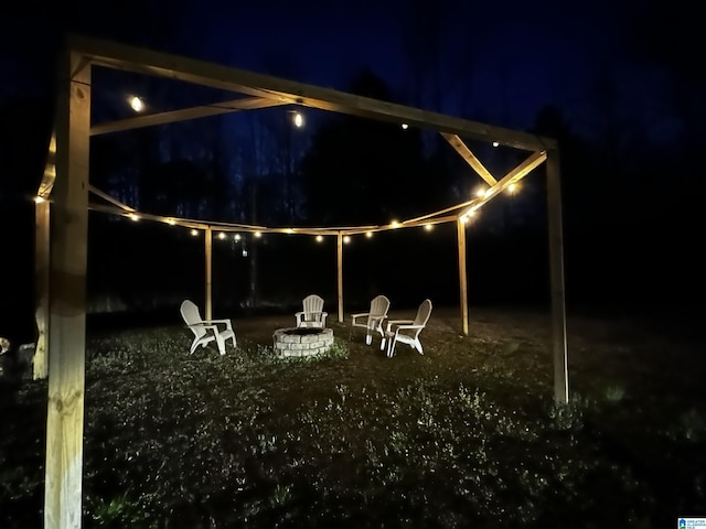 patio at night featuring an outdoor fire pit