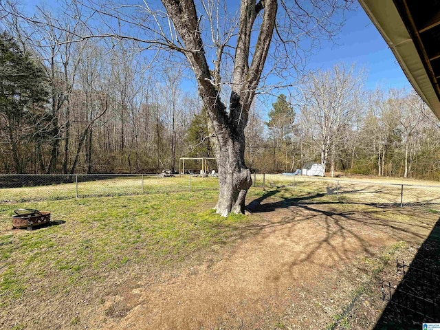 view of yard featuring an outdoor fire pit and fence