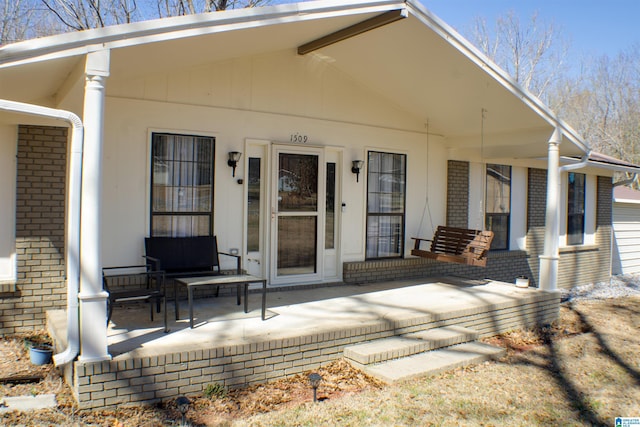 exterior space featuring a porch and brick siding