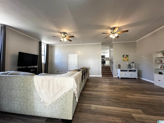 living room featuring baseboards, dark wood-type flooring, a ceiling fan, and crown molding