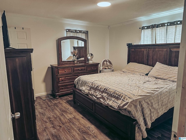 bedroom with dark wood-style floors, baseboards, and crown molding