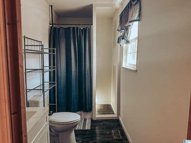 bathroom with curtained shower, wood finished floors, toilet, and baseboards