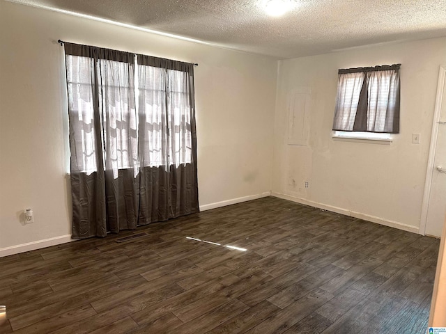 unfurnished room featuring a textured ceiling, baseboards, and dark wood-style flooring