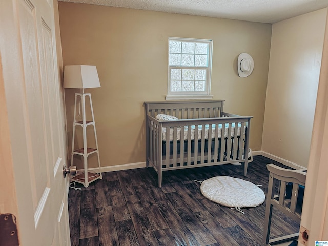 bedroom featuring a textured ceiling, wood finished floors, and baseboards