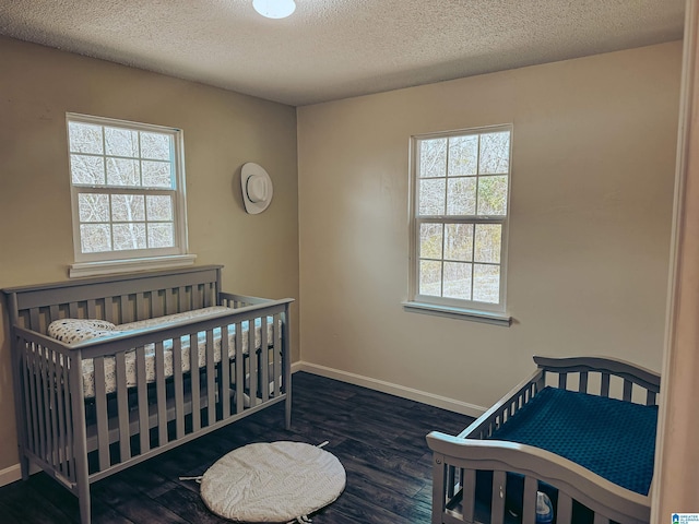 bedroom featuring a textured ceiling, baseboards, and wood finished floors