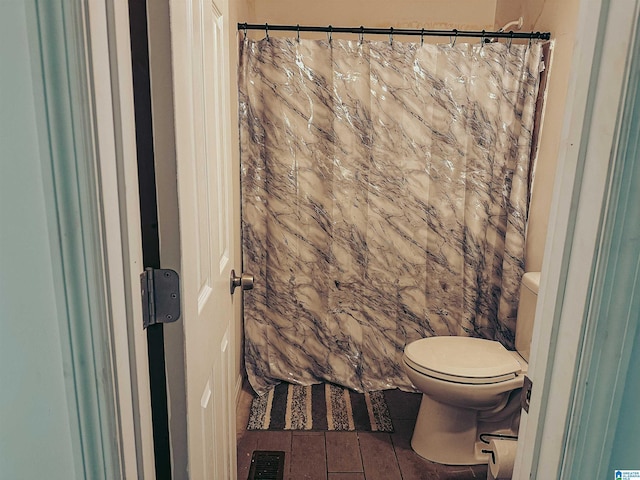 bathroom featuring a shower with shower curtain, visible vents, and toilet