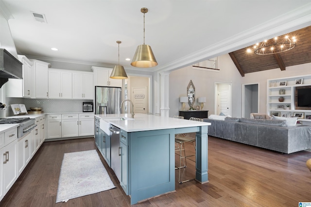 kitchen with visible vents, a sink, lofted ceiling with beams, open floor plan, and appliances with stainless steel finishes