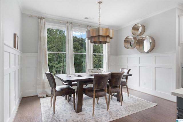 dining space with visible vents, crown molding, and wood finished floors