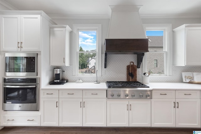 kitchen featuring a wealth of natural light, appliances with stainless steel finishes, and white cabinets