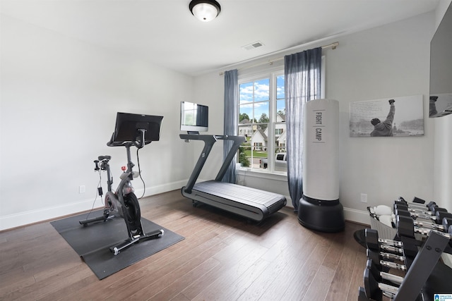 workout area featuring visible vents, baseboards, and wood finished floors