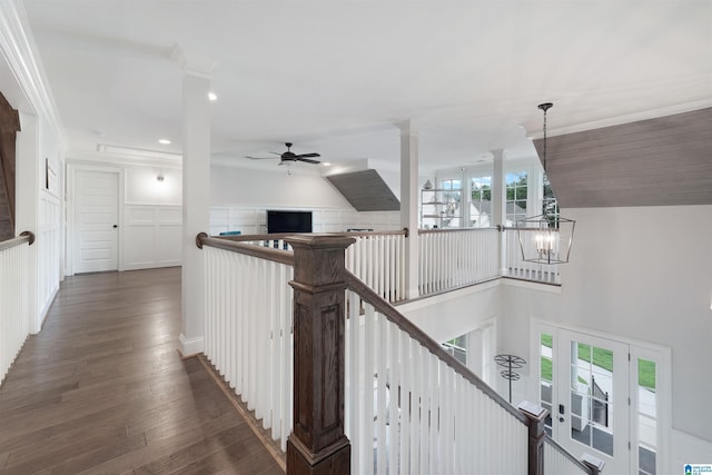 hall with an upstairs landing, a notable chandelier, dark wood-type flooring, and decorative columns