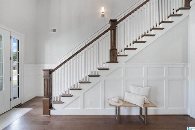 foyer with visible vents, stairway, wood finished floors, and a decorative wall