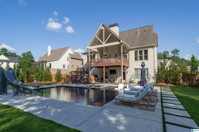 rear view of property with an outdoor hot tub, stairs, fence, a chimney, and a patio area