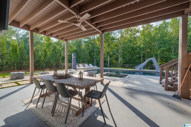 view of patio with an outdoor pool, outdoor dining area, ceiling fan, and fence