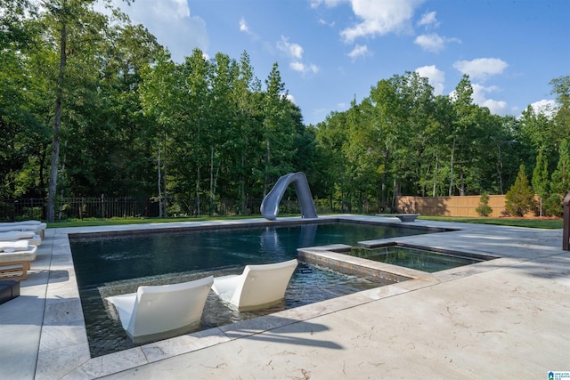 view of pool featuring a fenced in pool, a water slide, fence, a patio area, and an in ground hot tub