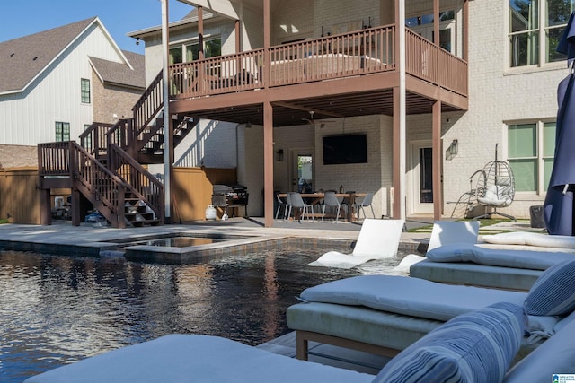 exterior space with an outdoor pool, stairway, and an in ground hot tub