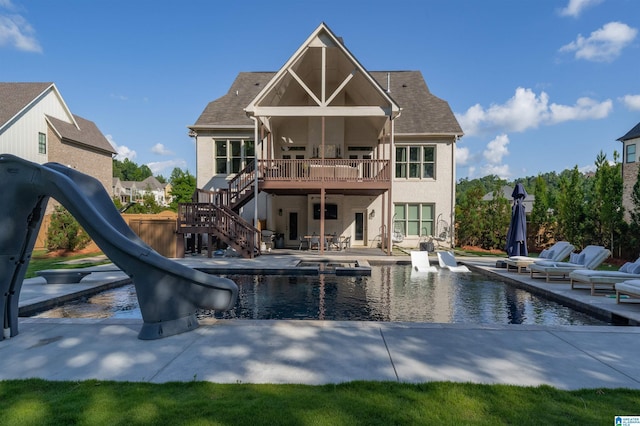 rear view of property featuring an outdoor pool, a wooden deck, a patio, and stairway