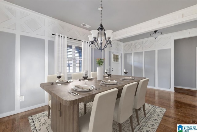 dining space featuring an inviting chandelier, baseboards, visible vents, and wood finished floors